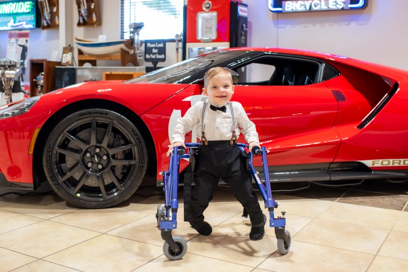 boy in front of red ford race car